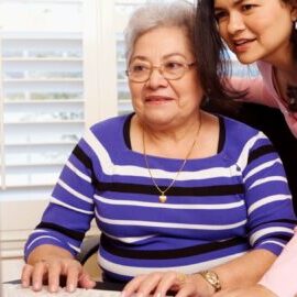 young woman helping elderly woman at the computer